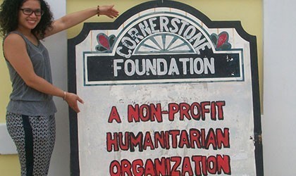 Vet intern pose with Cornerstone foundation signage